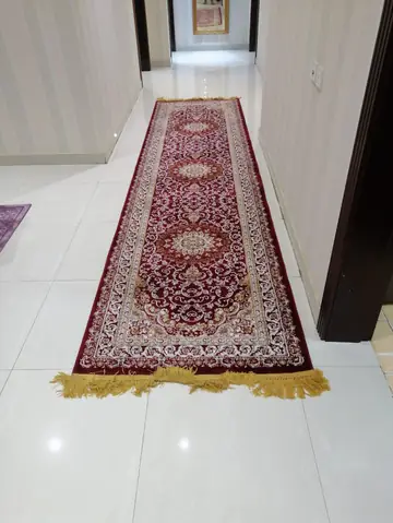 A red runner carpet on a glossy marble floor
