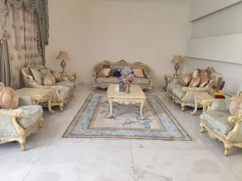 غرفة جلوس فيها أرائك كلاسيكية وسجادة نظيفة بعد التنظيف